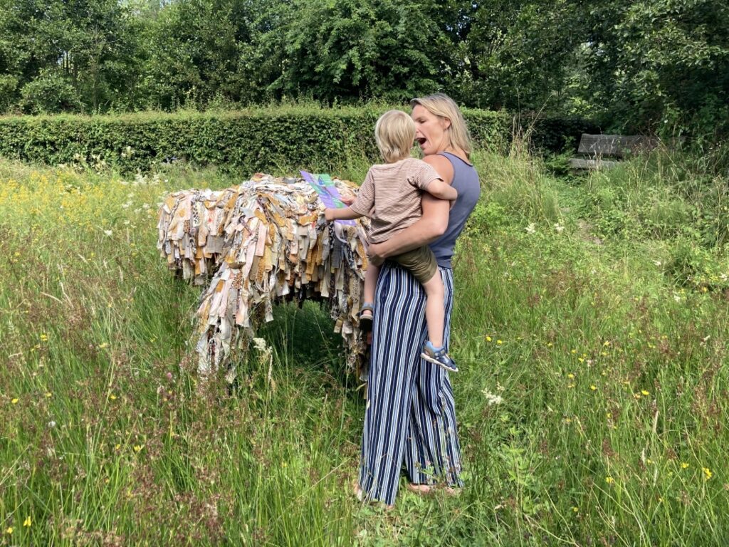 Moeder met kind met speurtocht bij beeld